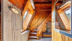 Un intérieur en bois avec un plafond en pente, un escalier et une fenêtre.