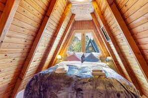 A wooden attic bedroom with a bed, pillows, and a window. - Holiday Home 'Villa Natura' with Mountain View, Terrace, Garden & Wi-Fi (Meschede)