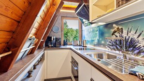 Une cuisine au design moderne, équipée d’un évier en acier inoxydable, d’une machine à café et d’un grille-pain.