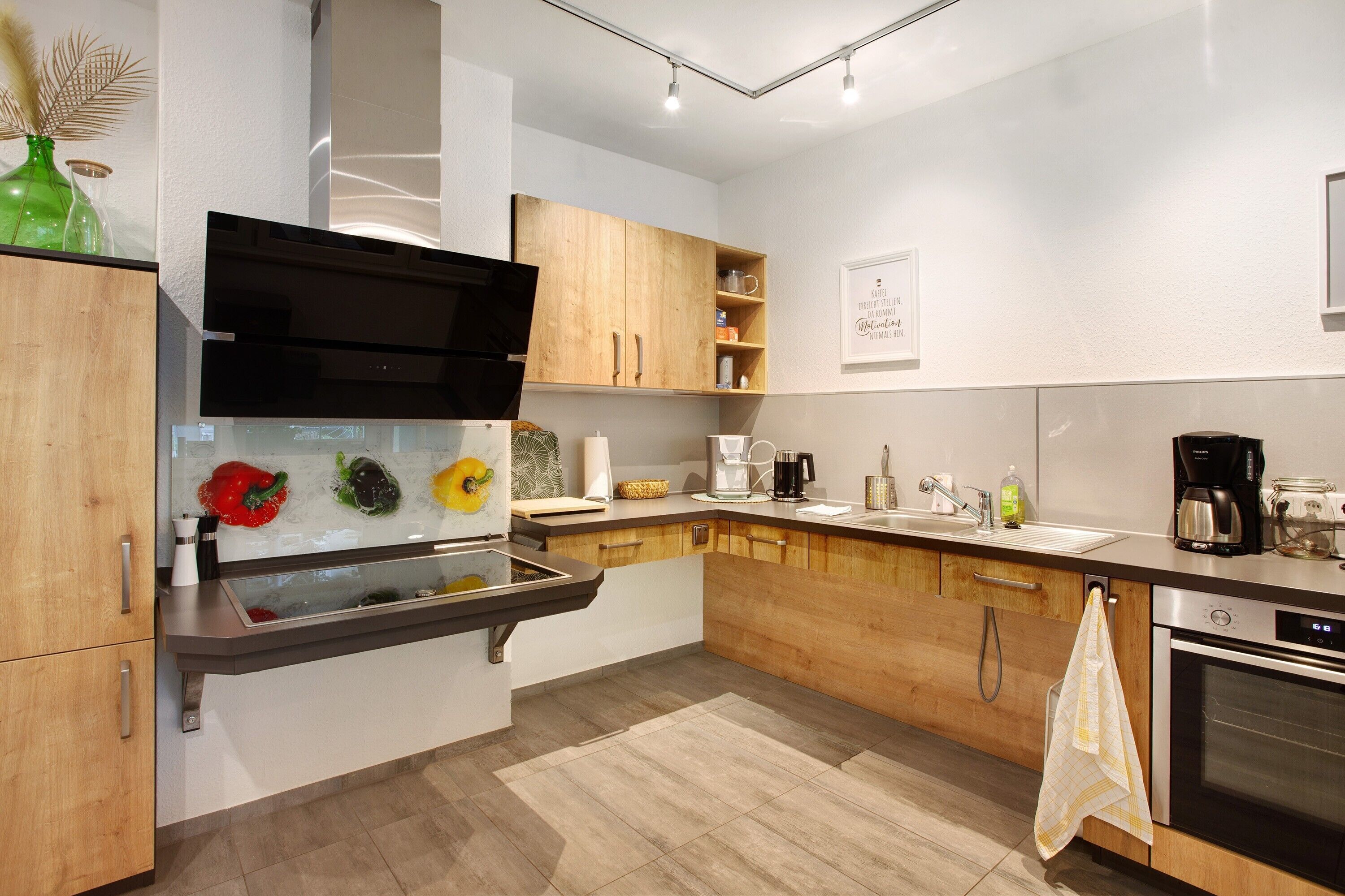 A modern kitchen with wooden cabinets, a built-in oven, and a microwave.
