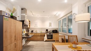 Una cocina moderna con armarios de madera, una mesa de comedor y un ventanal grande.