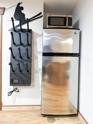 A stainless steel refrigerator with a microwave on top, a black knife block with knives, and a power outlet on the wall. - SKI IN/OUT- Pool table, hot tub, A+ kitchen, 7 bedrooms->4 kings+custom kid rms! (Snowshoe)