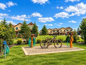 A residential area with houses, a grassy lawn, and a bicycle in the foreground.