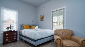A bedroom with a bed, a dresser, a chair, and two windows with blinds. - 3 Bedroom 3 Bath House  in Atlanta -Two Blocks To GWCC, Mercedes-Benz Stadium  (Atlanta)