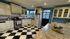 A kitchen with white cabinets, a black and white checkered floor, and a granite countertop. - A Magical Place just Minutes away from the most Beautiful View of Cuenca.  (Cuenca)