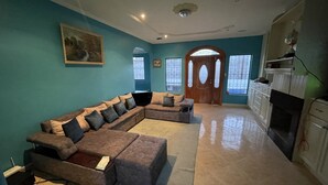 A spacious living room with a large sectional sofa, a fireplace, and a kitchen area. - A Magical Place just Minutes away from the most Beautiful View of Cuenca.  (Cuenca)