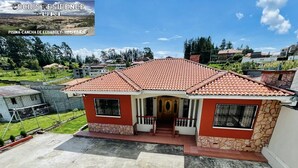 A two-story house with a red-tiled roof, a stone foundation, and a small porch with a wooden door. - A Magical Place just Minutes away from the most Beautiful View of Cuenca.  (Cuenca)