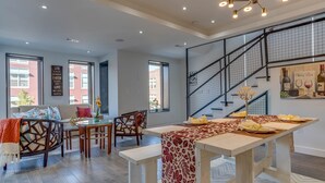 Een moderne woonkamer met een eethoek, een trap en grote ramen.