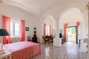 Une pièce comprenant un lit, une table et des chaises, avec vue sur l’extérieur et une porte donnant sur un patio.