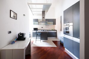 A modern kitchen with a central island, a microwave, and a built-in oven. - Casa Aosta in Rome With 1 Bedrooms and 1 Bathrooms (Rome)