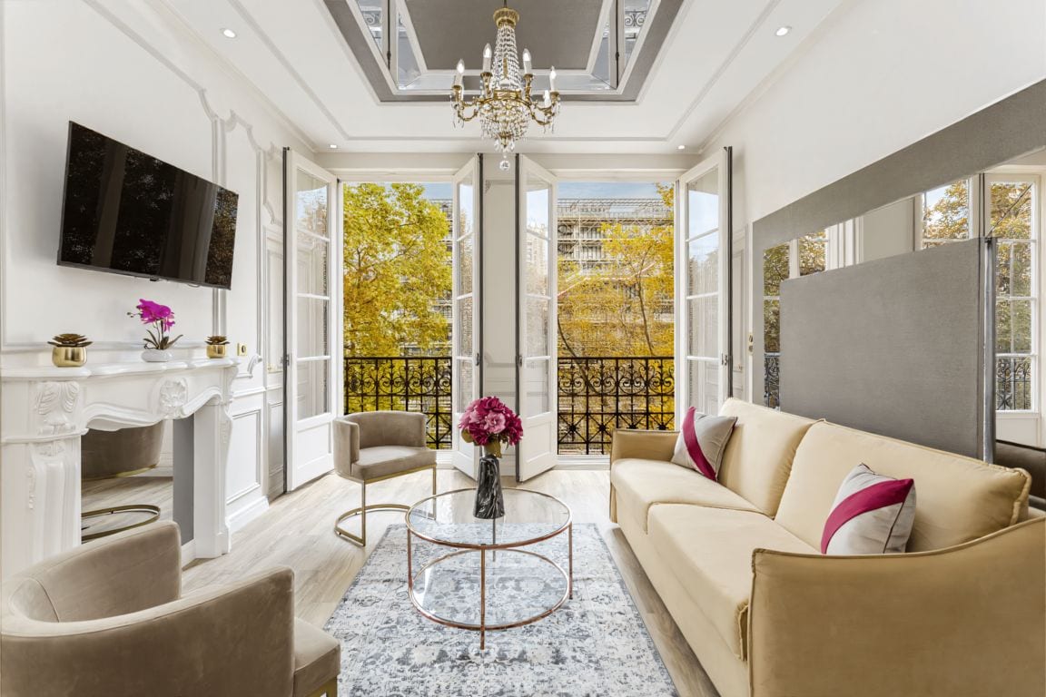 A spacious living room with a large sofa, a coffee table, and a fireplace.