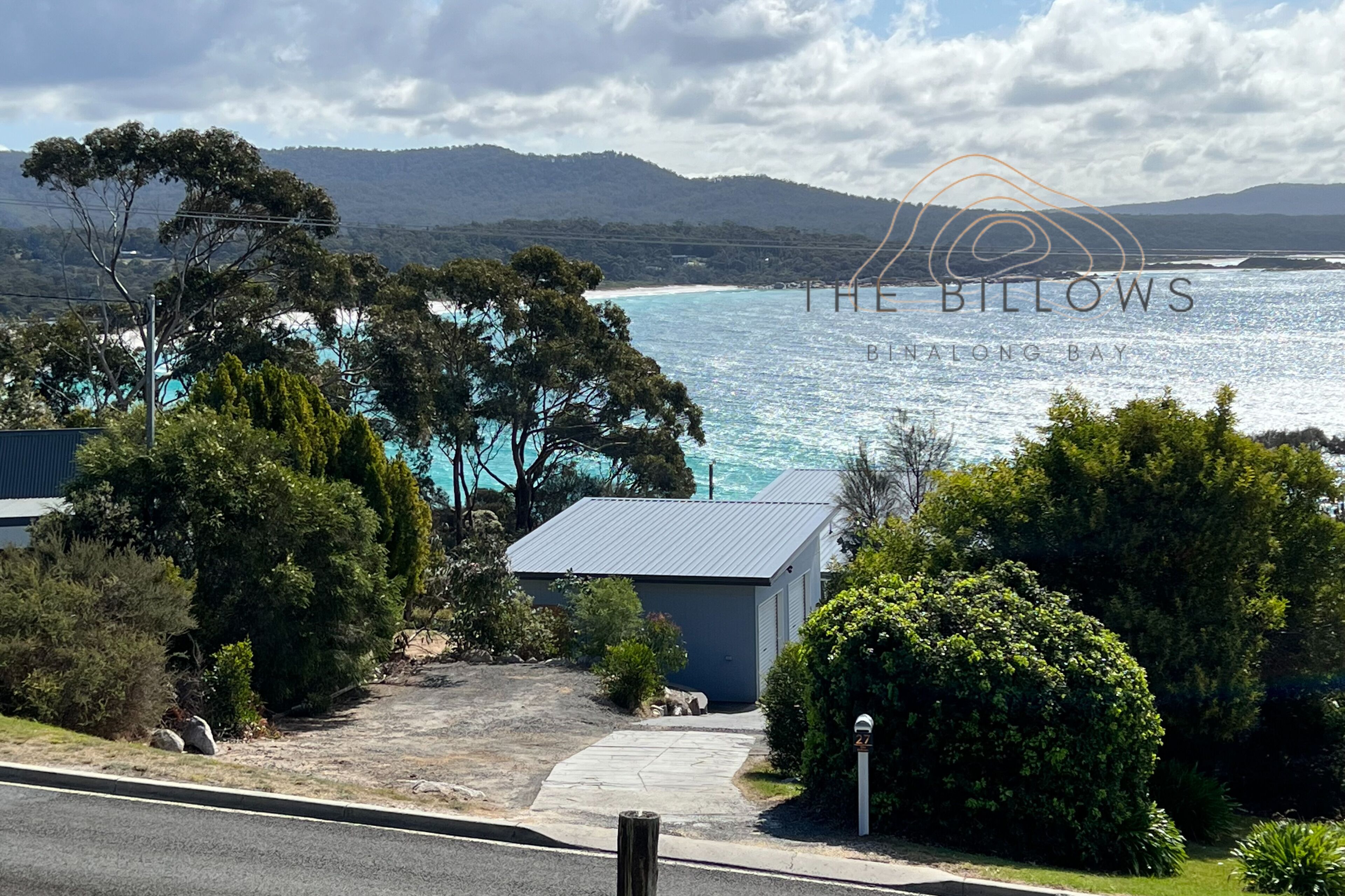 A coastal property with a view of the sea and hills.