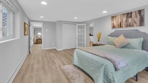 A bedroom with a bed, a nightstand, a painting, and a door leading to another room. - Tranquil retreat in Fairfax: your home away from home (Fairfax)