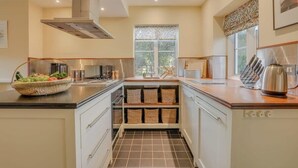 Una cocina moderna con una isla central, estanterías empotradas y un ventanal con vistas.