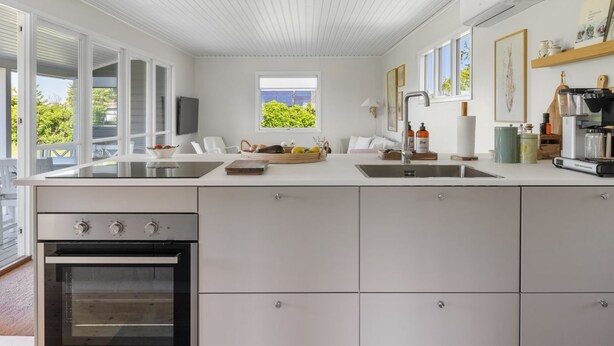 A modern kitchen with a large island, built-in oven, and a view of the outdoors. - "Iven" - 140m from the sea by Interhome (Otterup)
