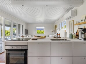 A modern kitchen with a large island, built-in oven, and a view of the outdoors. - "Iven" - 140m from the sea by Interhome (Otterup)