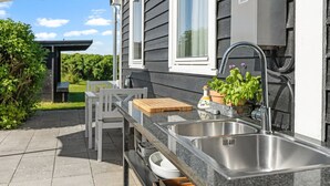 An outdoor kitchen with a sink, a wooden cutting board, and potted plants. - "Iven" - 140m from the sea by Interhome (Otterup)