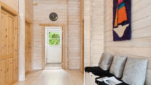 Un interior de madera con una mesa de recepción, un reloj y un tapete estampado.
