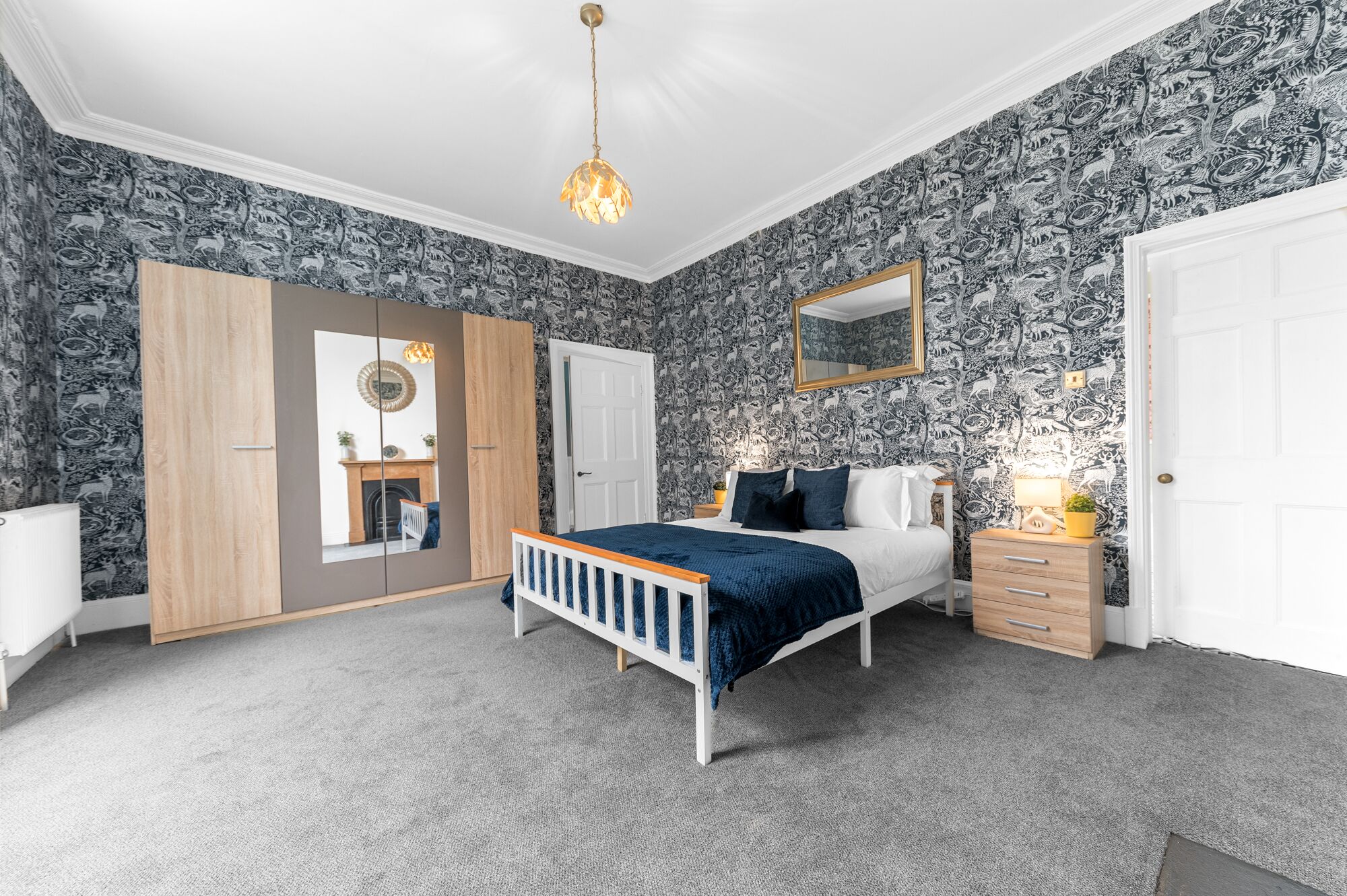 A bedroom with a bed, dresser, and wardrobe.