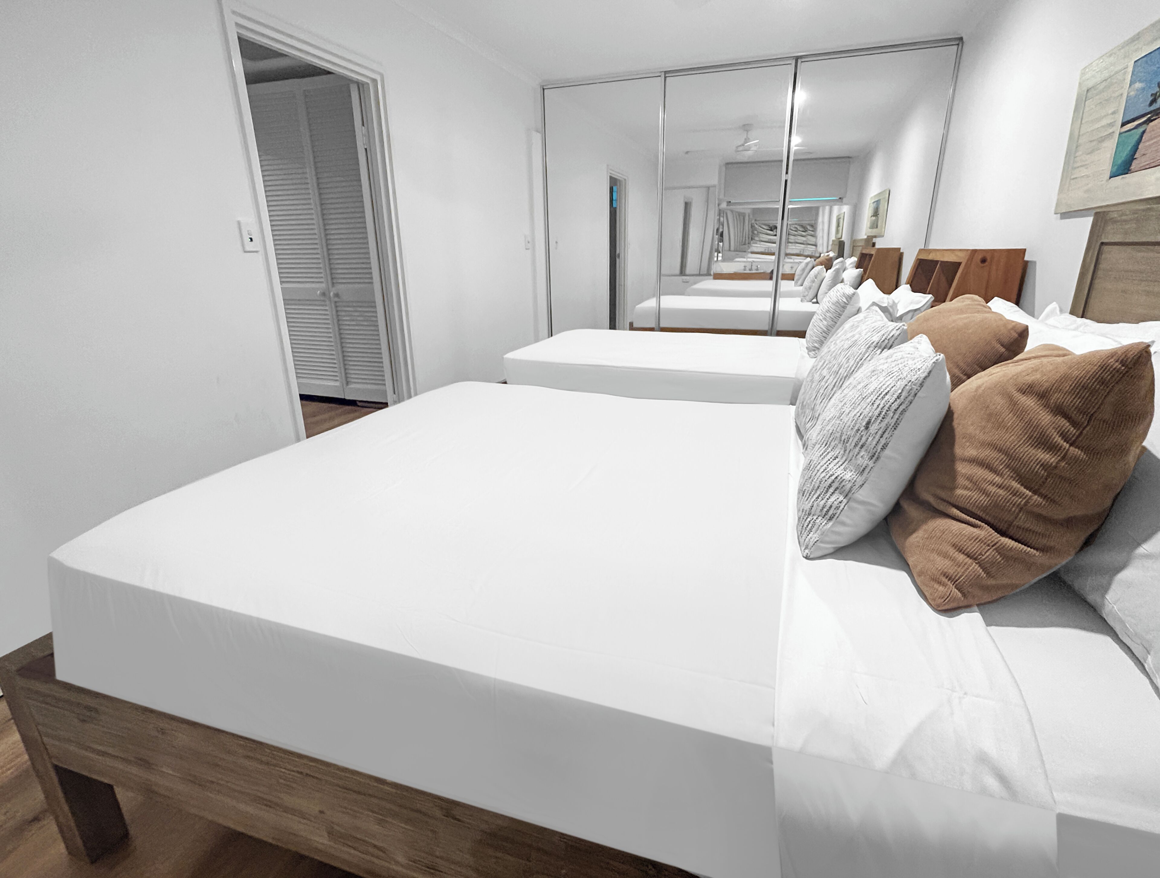 Une chambre à coucher avec un grand lit, un miroir et une porte donnant sur un placard.
