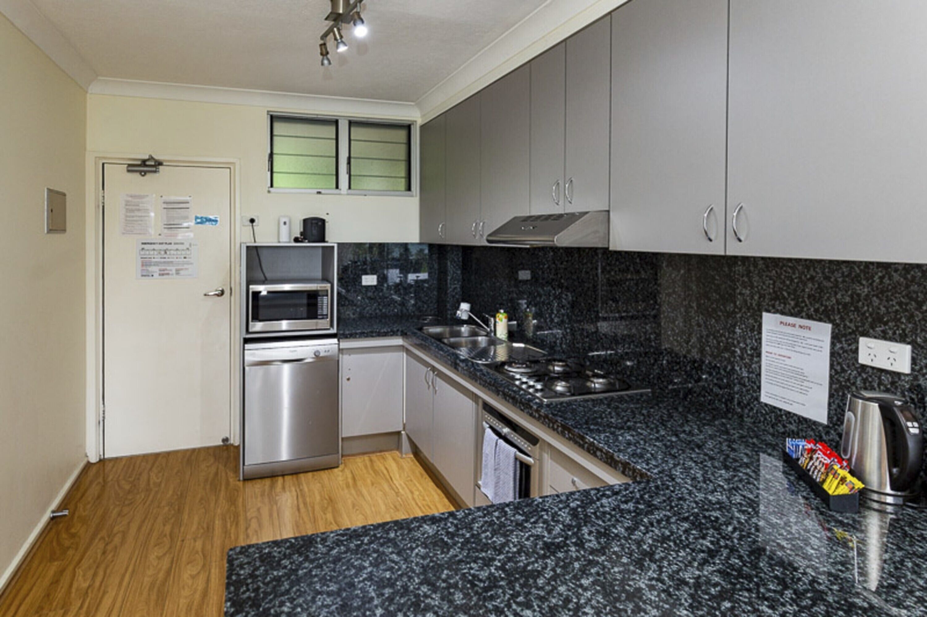Eine moderne Küche mit Granit-Arbeitsplatten, Edelstahlgeräten und einem eingebauten Backofen.