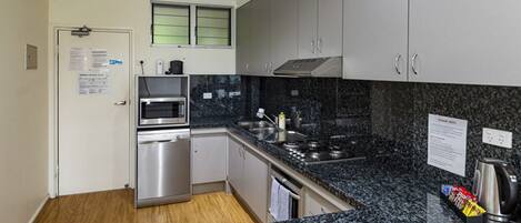 Eine moderne Küche mit Granit-Arbeitsplatten, Edelstahlgeräten und einem eingebauten Backofen.