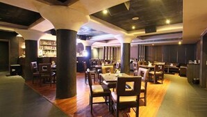 Un restaurante espacioso con techos altos, suelo de madera y una zona de bar.