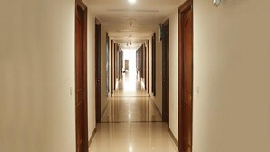 Un pasillo largo y estrecho con puertas a ambos lados que dan a habitaciones.