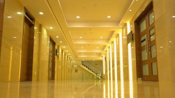 Un pasillo largo y bien iluminado con una escalera que lleva a un nivel superior.