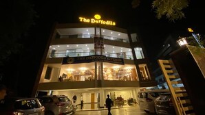 The Daffodils restaurant with a sign above the entrance, a visible outdoor seating area, and a person walking in front. - Fabhotel Prime The Daffodils (Dehradun)