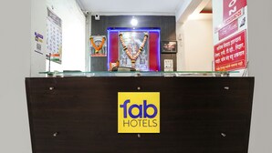 A reception desk with a 'fab hotels' sign, a calendar, and a framed picture on the wall. - Fabhotel Silver Inn Ii (Nashik)