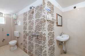Une salle de bain équipée de toilettes, d’une douche et d’un lavabo.