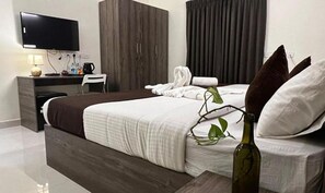 A modern hotel room with a large bed, a desk, a flat-screen TV, and a plant. - Fabhotel I Live Inn (Chennai)