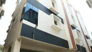 Un immeuble résidentiel à plusieurs étages, doté d’une architecture moderne et caractérisé par une combinaison de couleurs : blanc, noir et rouge.