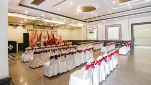 A spacious hall with rows of chairs, a stage, and a podium. - Fabhotel Jalandhar Corporate Suites (Jalandhar)