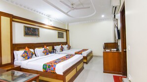 A hotel room with two beds, a desk, a chair, a ceiling fan, an air conditioning unit, and a television. - Fabhotel Jalandhar Corporate Suites (Jalandhar)
