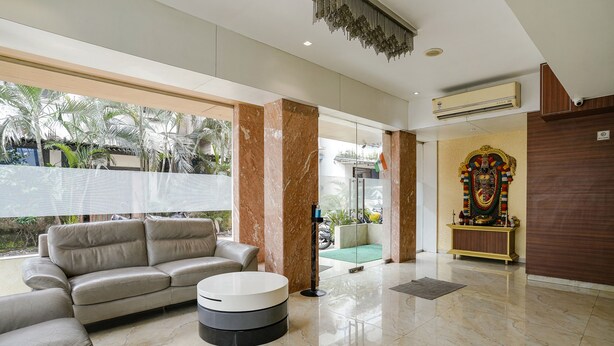 A modern lobby with a leather sofa, a round coffee table, and a decorative shrine. - Fabhotel Konar Inn (Navi Mumbai)