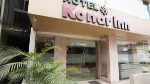 The exterior of HOTEL Kandar Inn with a glass entrance and visible interior seating. - Fabhotel Konar Inn (Navi Mumbai)