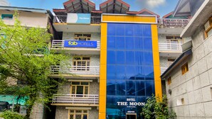 Un hotel llamado "The Moon" con fachada azul y amarilla, balcones y un letrero que dice "abHOTELS".