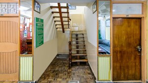 Una escalera con barandilla de madera que lleva a una habitación con un letrero verde en la pared.