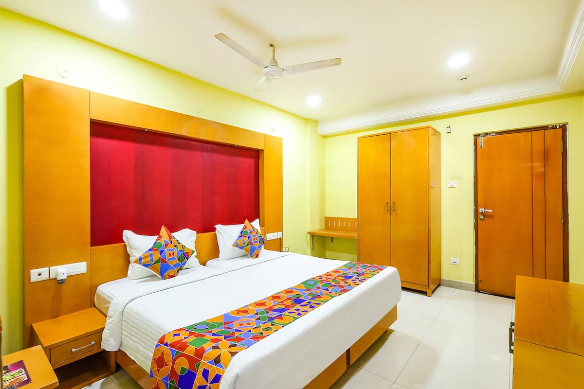 A hotel room with a bed, nightstand, wardrobe, and a ceiling fan.