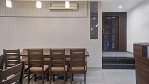 Ett konferensrum med ett långt bord och sex stolar, en luftkonditioneringsanläggning på väggen och en dörr av trä med glaspaneler.