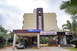A building with a sign for 'fab hotels' and a 'family restaurant bar' on the ground floor. - Fabhotel Prime Shahu (Sinnar)