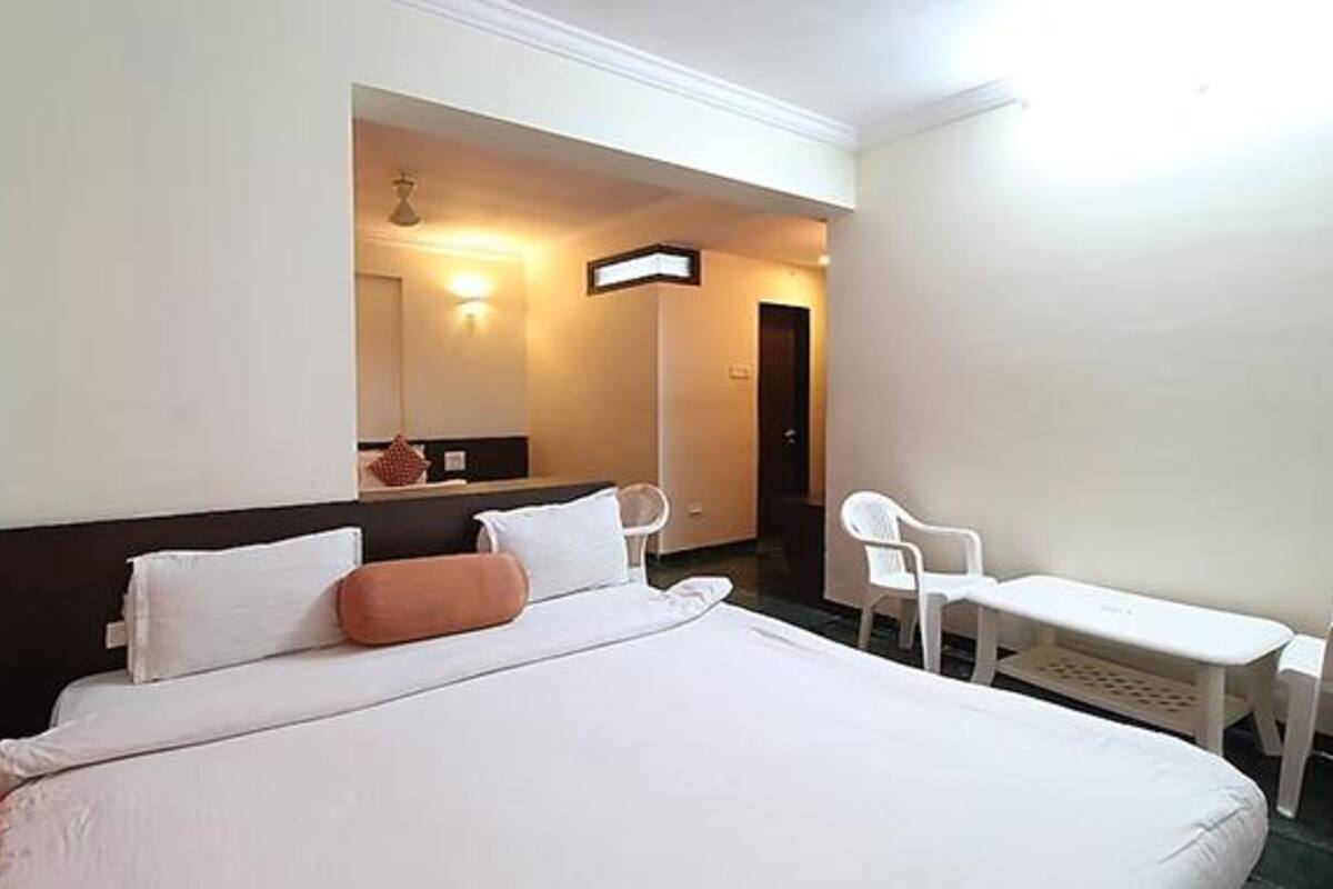 A hotel room with a bed, a desk, and a chair.