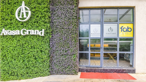 A hotel entrance with a green wall and a red mat. - Fabhotel Avasa Grand (Panaji)