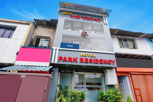 A hotel with a sign indicating 'HOTEL PARK RESIDENCY' and a logo above the entrance.