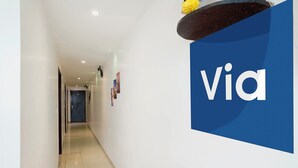 A hallway with a blue sign reading 'Via' on the wall. - Fabexpress Park Residency (Mumbai)