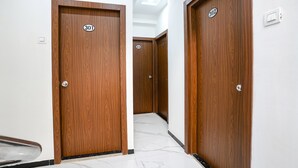 A corridor with wooden doors numbered 301 and 302, leading to a room. - Fabhotel Fortuna Inn (Navi Mumbai)