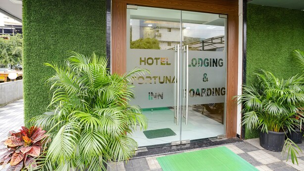 A hotel entrance with a green wall and glass doors. - Fabhotel Fortuna Inn (Navi Mumbai)