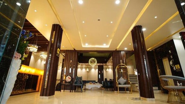 A spacious lobby with a high ceiling, modern chandeliers, and a reception area with a counter and seating. - Fabhotel Prime Orange Tree (Nagpur)